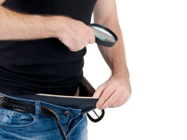 muž se dívá dolů do kalhot a chce si zvětšit penis